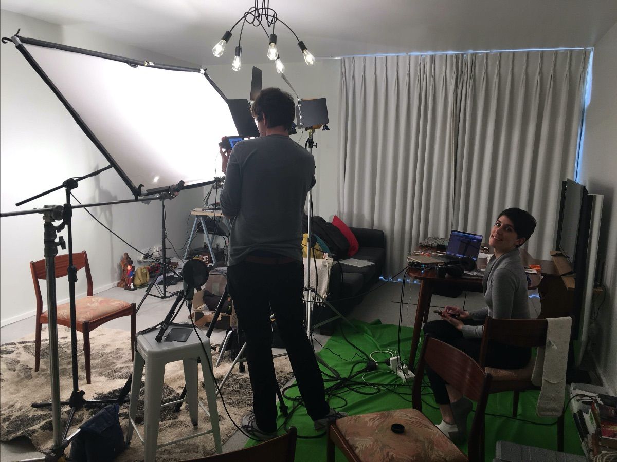 A photo of two people filming a video in a living room