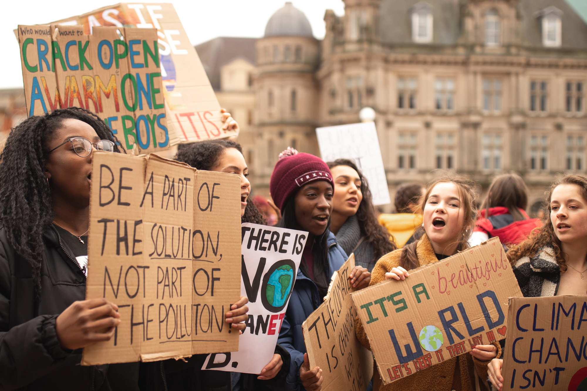 teen holding up a poster saying "be a part of the solution, not part of the pollution"