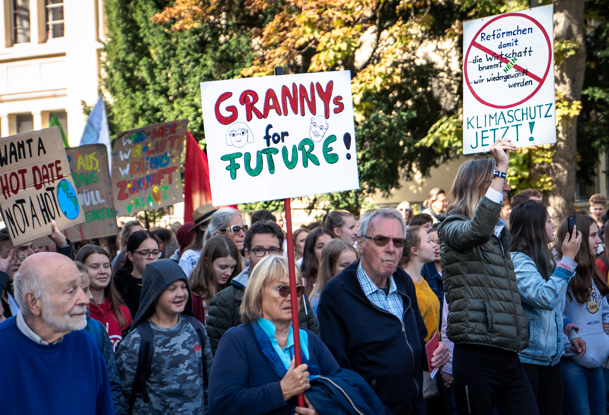 People protesting, one woman holding a sign saying granny's for future