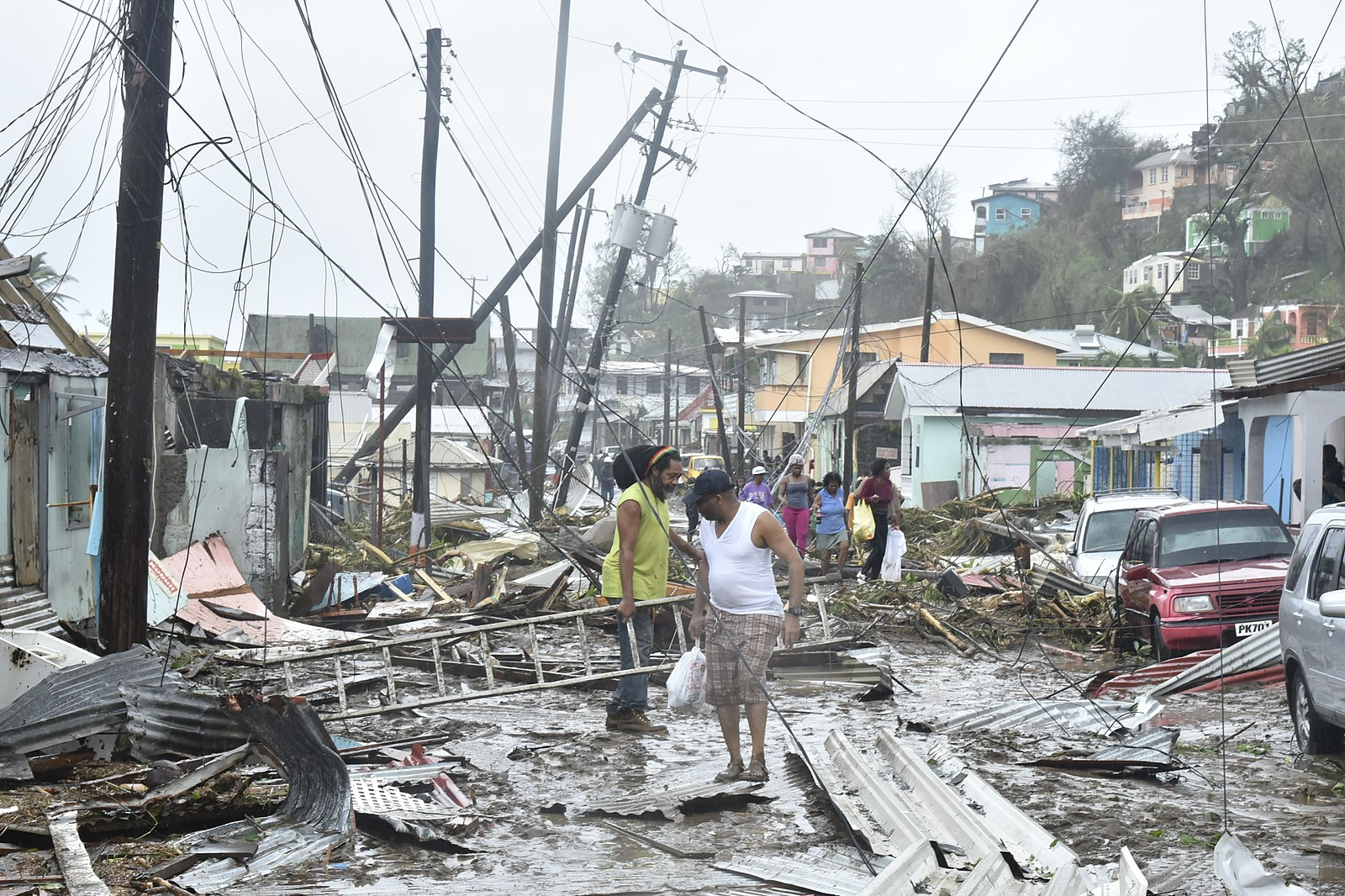 People walking through a street that was destroyed by Hurricane Maria
