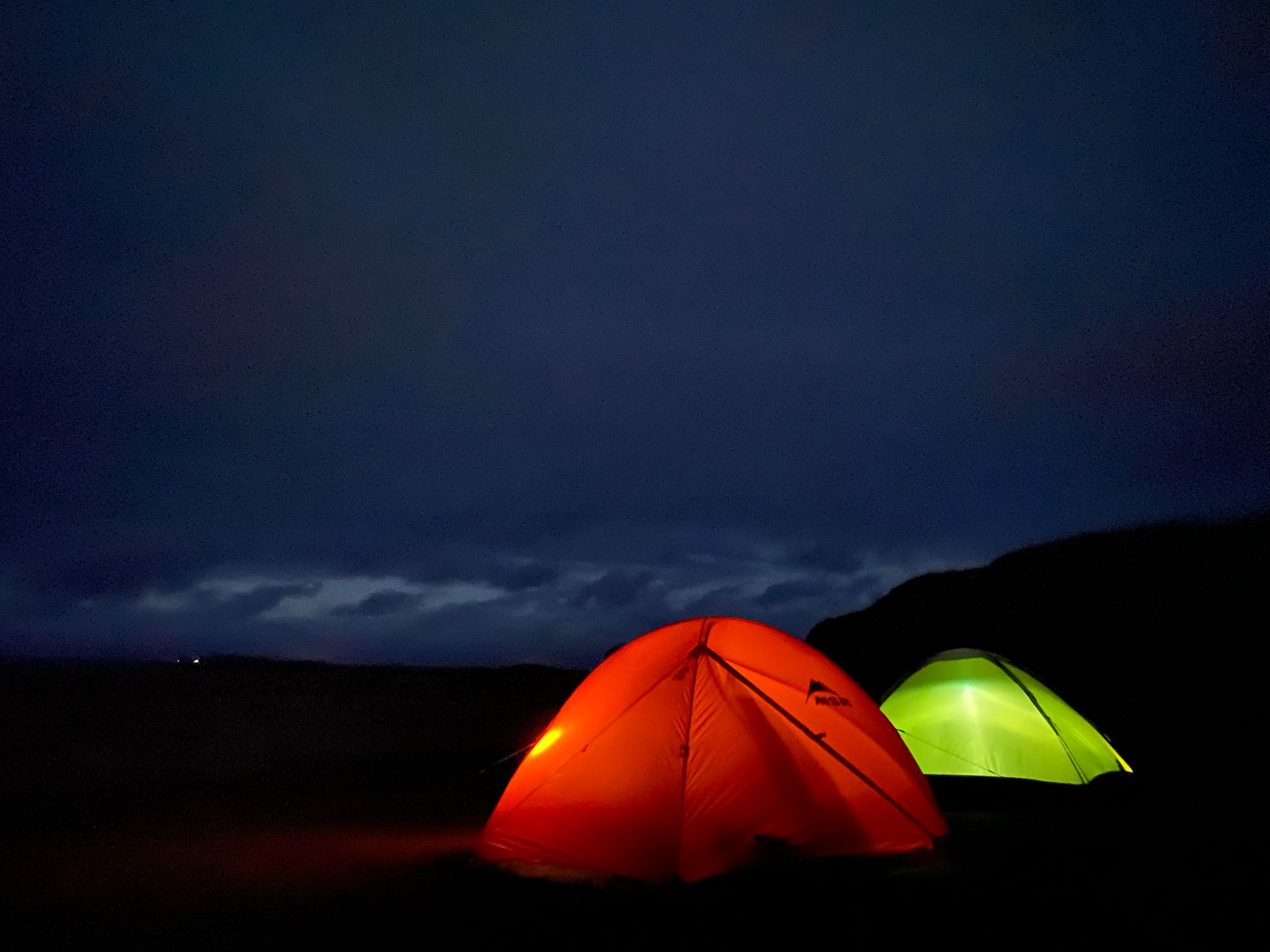 Two tents glowing in the darkness