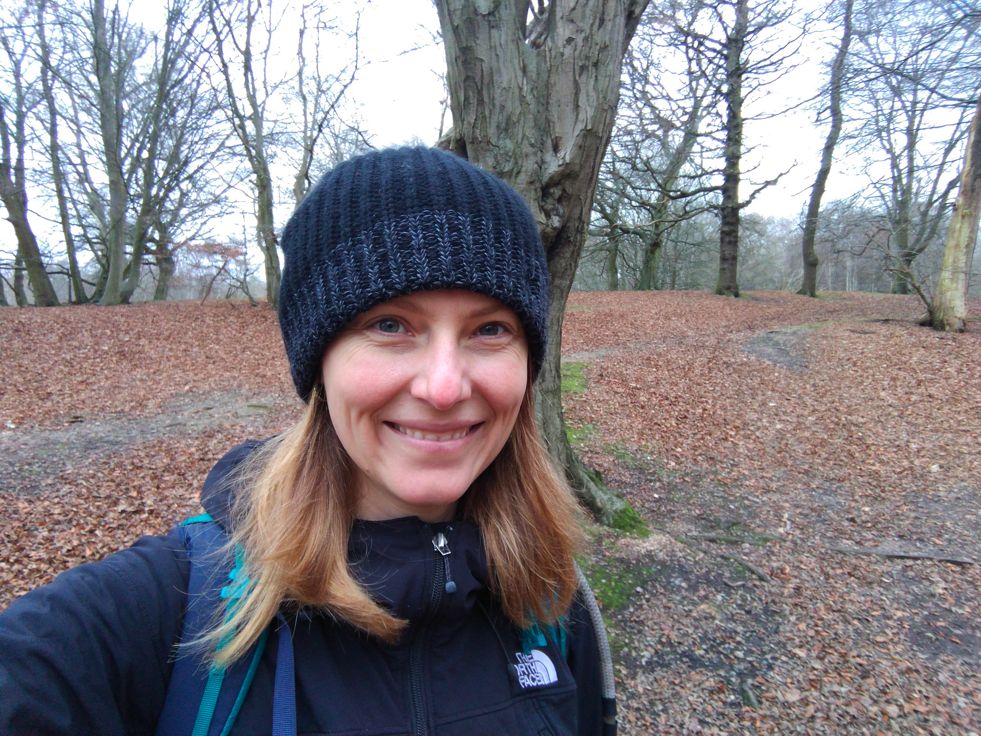 Sam standing in Epping Forest wearing a beanie