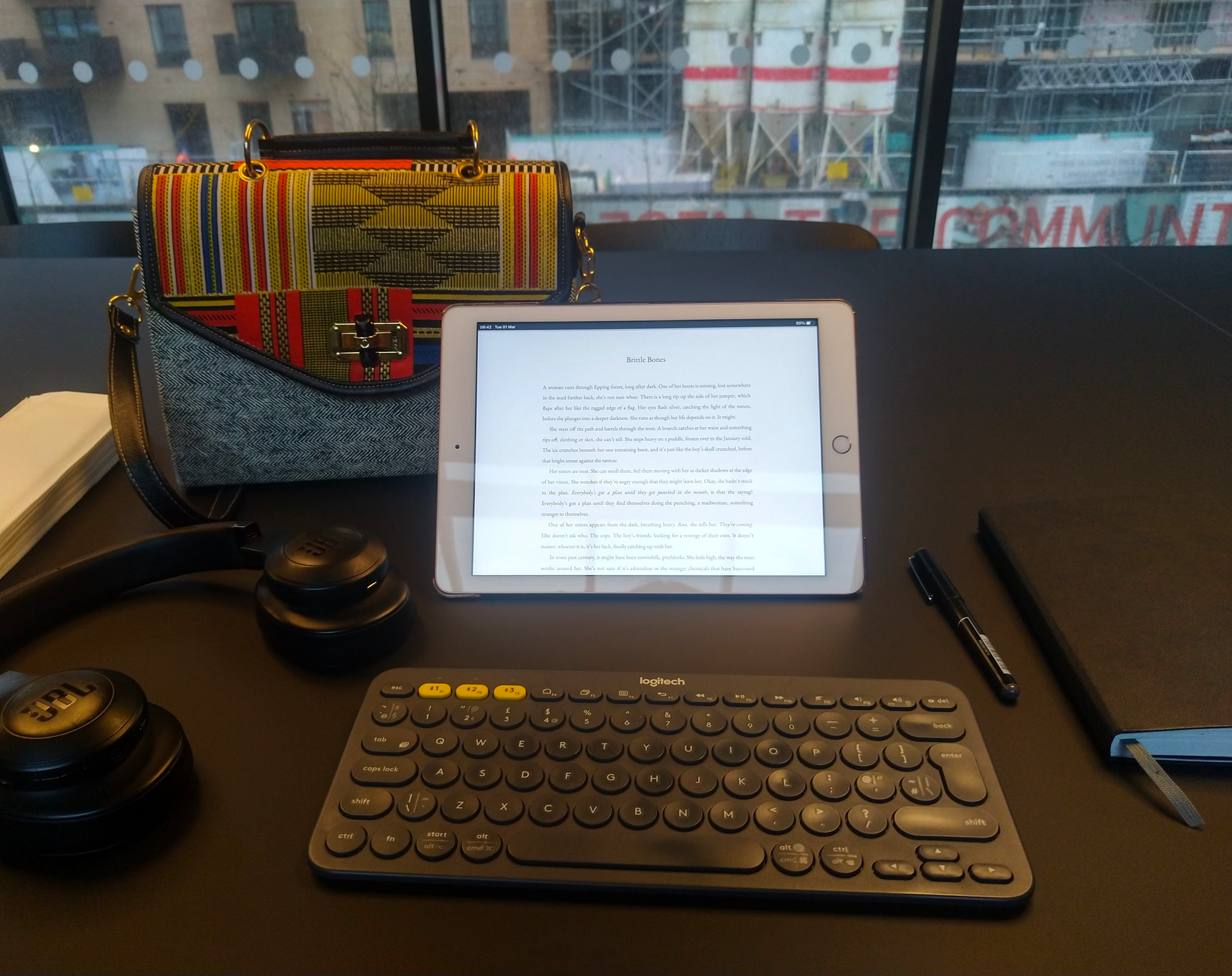 an iPad, keyboard, pen and notebook