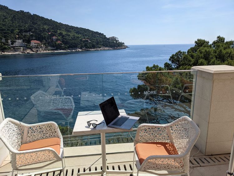 A laptop in front of a view of the Adriatic sea.