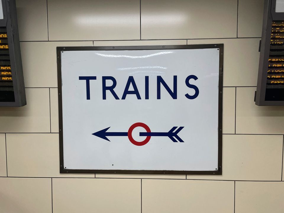 A sign pointing to trains in a nifty font
